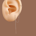 Three silver-toned chain ear piercings displayed on a beige silicone human ear model against a solid brown background.