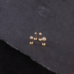 Set of gold-colored studs on a dark stone surface