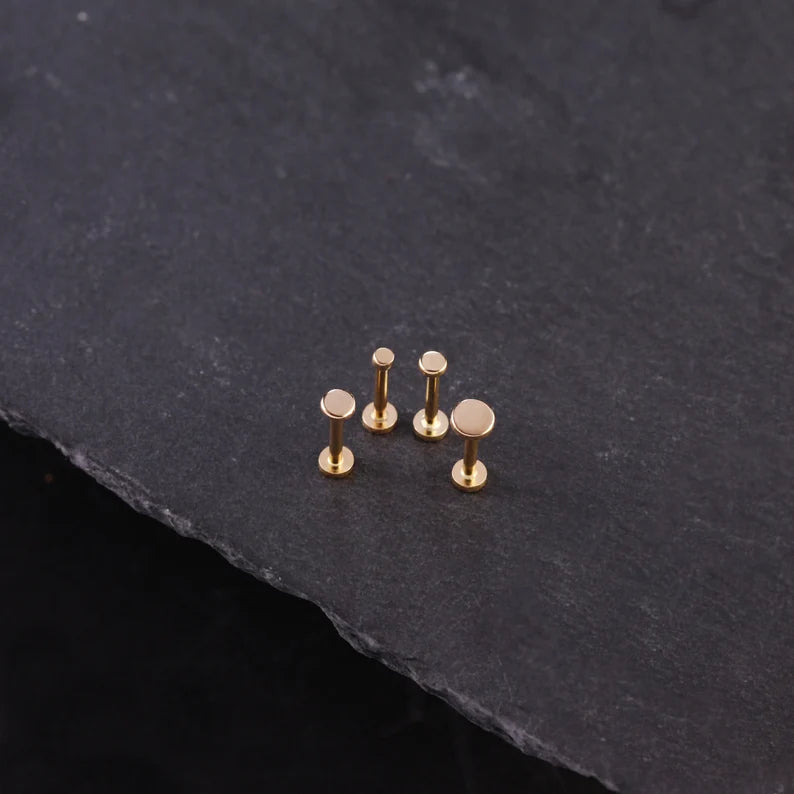 Set of gold-colored studs on a dark stone surface