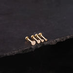 Set of gold earrings on a dark stone surface