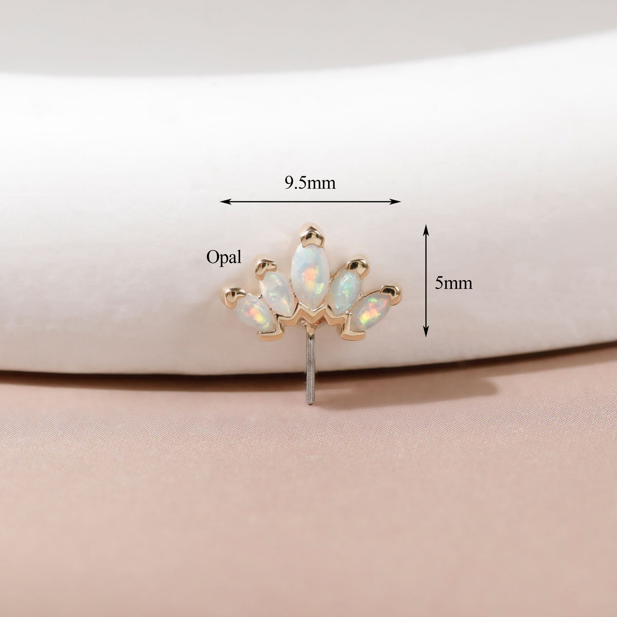 A small gold-toned stud earring with five iridescent opal stones arranged in a fan shape, shown on a soft beige surface with overlaid dimension arrows and labels reading 9.5mm and 5mm.